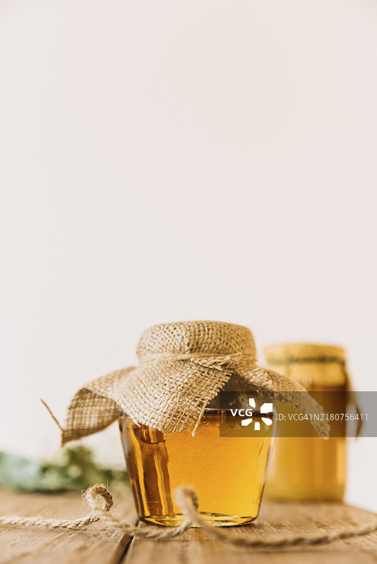 蜂蜜罐与木质表面图片素材