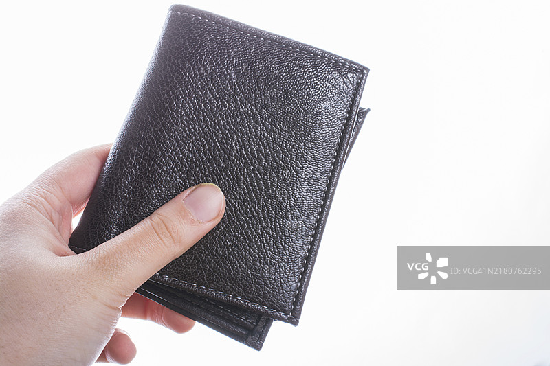 手持棕色皮革钱包，储蓄和金融概念图片素材