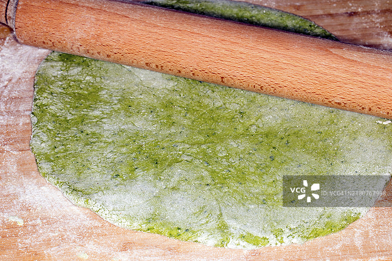 用擀面杖擀出的菠菜意大利面面团图片素材