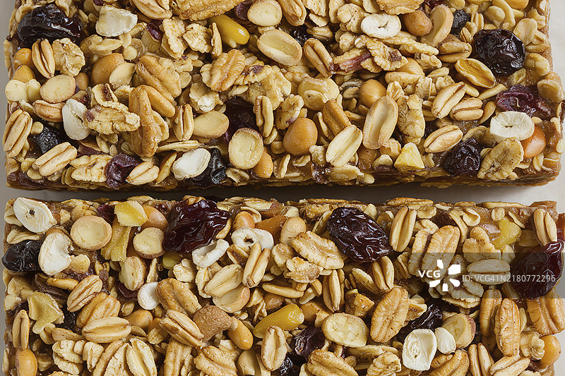 一张矩形燕麦棒的照片，里面含有浓密的燕麦、坚果和干果混合物。图片素材