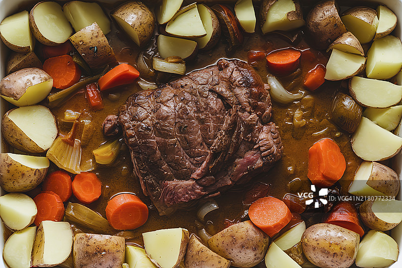 烤盘中放有切丁土豆和温热的肉炖菜图片素材