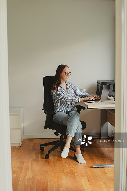 年轻女性在办公室使用笔记本电脑工作图片素材