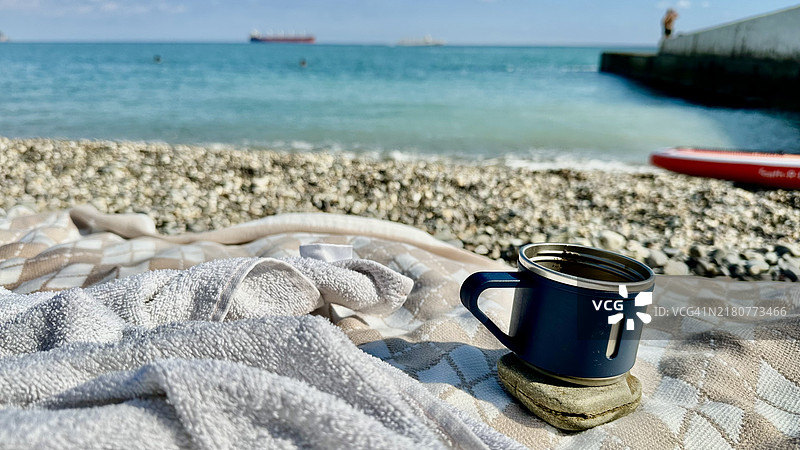 海滩上咖啡杯的特写，背景是天空，乌克兰图片素材
