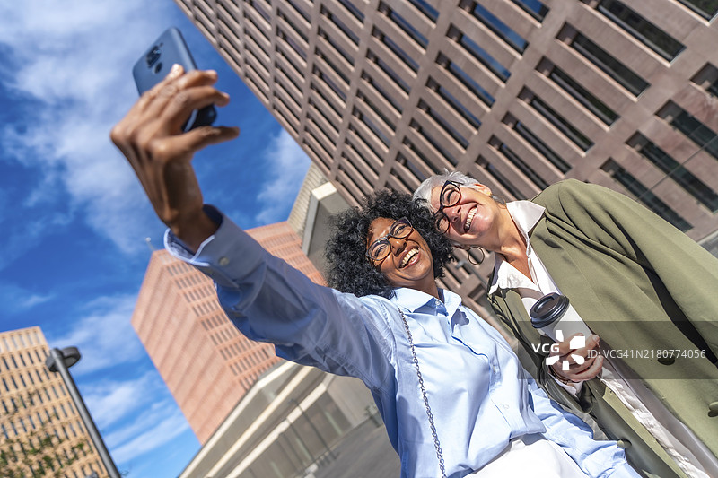 多文化女商人户外自拍，笑容满面图片素材