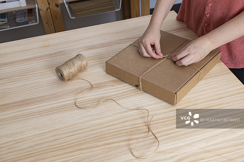 拥有长发的年轻棕发女孩正在为她的小企业打包订单图片素材