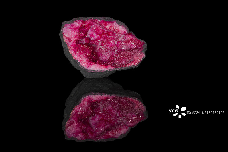 粉色石英晶洞，黑色背景的影棚摄影图片素材