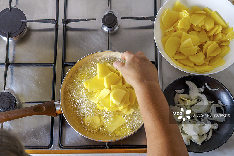 特写：女人在煎锅里炸土豆图片素材