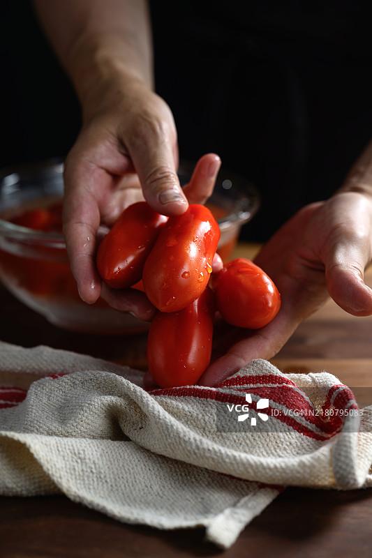 女人的手握着碗里的番茄，特写镜头图片素材