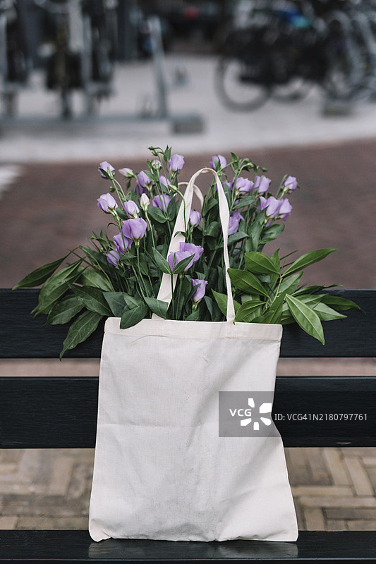白色棉布手提包与紫色洋桔梗图片素材