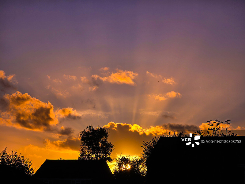 房屋、树木、云朵与橙紫色天空的日落图片素材