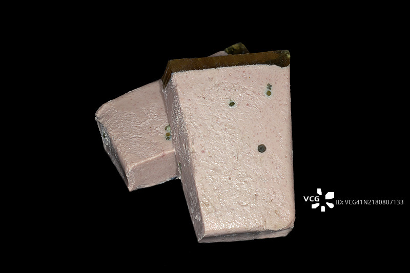 黑背景下的对半切开的肉酱冻和新鲜青椒，工作室摄影图片素材