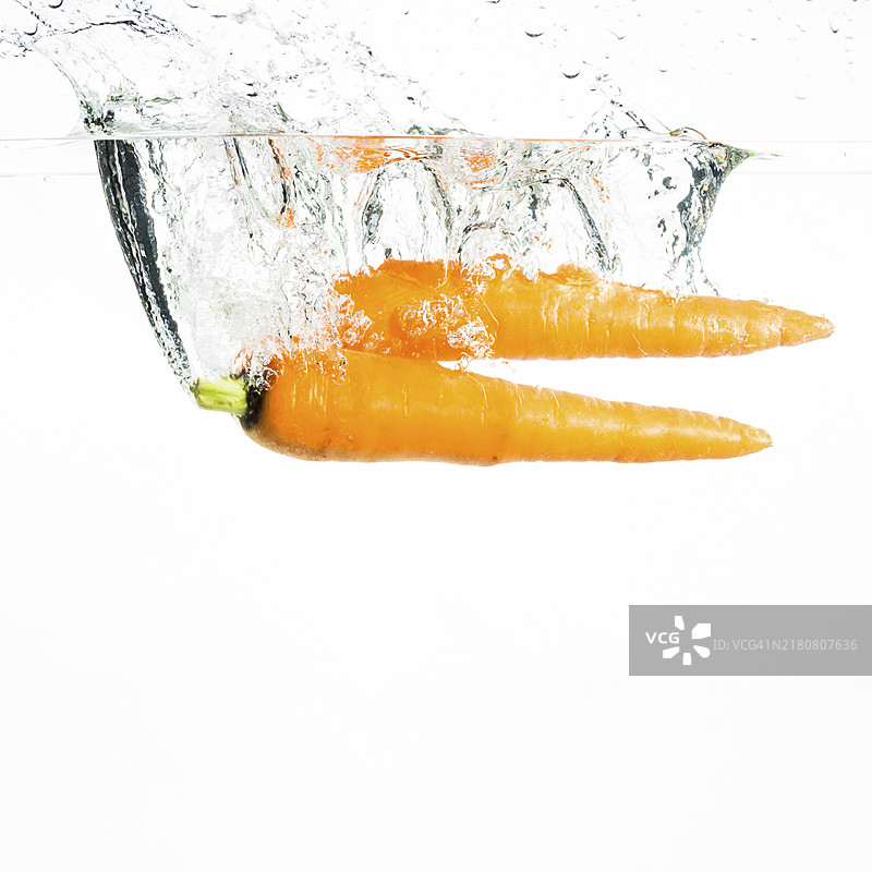 两根胡萝卜在白色背景下溅水图片素材