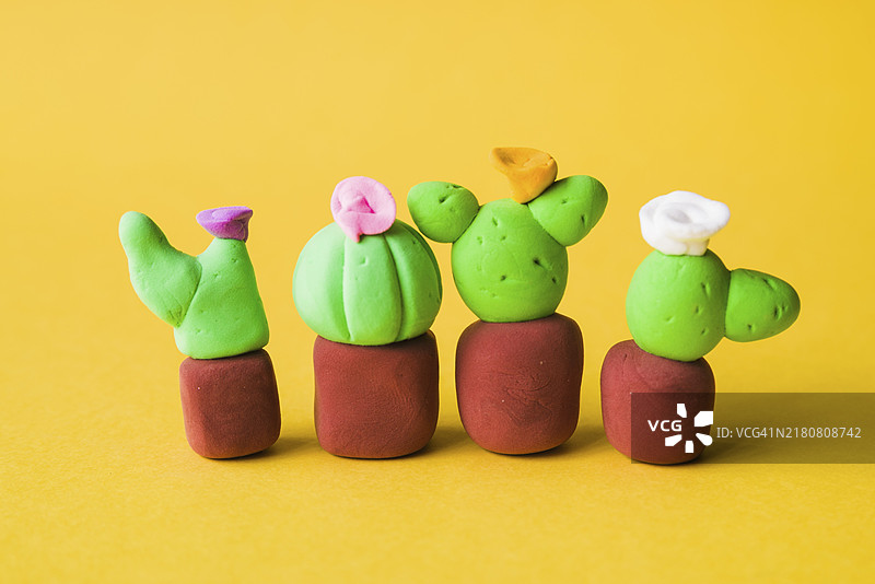 黄色背景上的黏土仙人掌盆栽图片素材