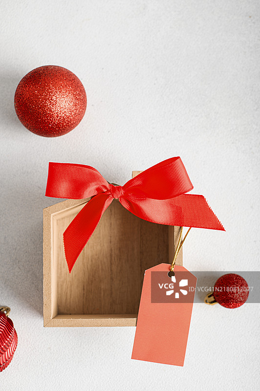 白色背景上带红色蝴蝶结、空白标签和圣诞球的木制房屋模型图片素材