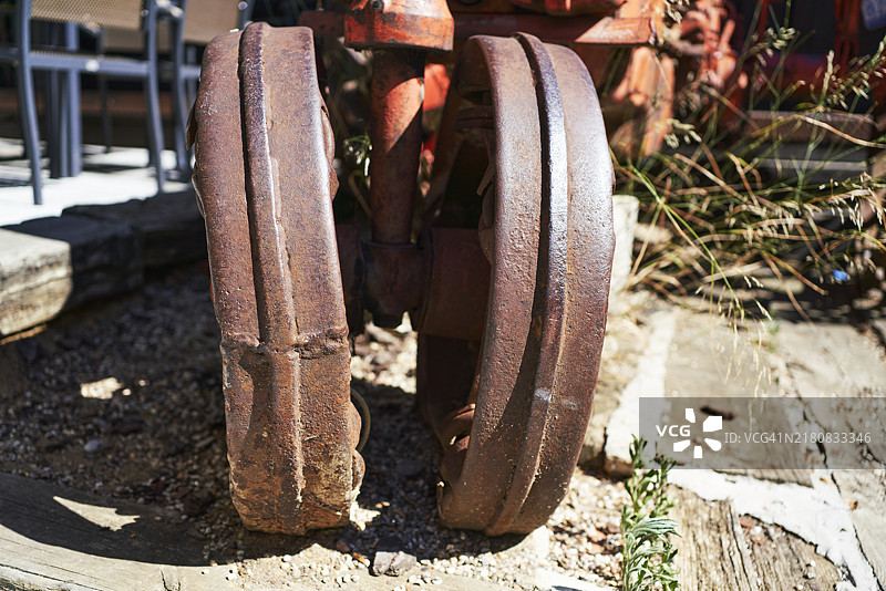 仓库中废弃拖拉机的前轮特写图片素材