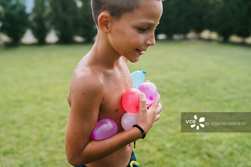 手里拿着水球炸弹的快乐男孩图片素材