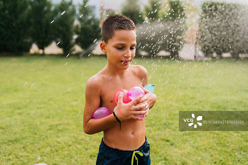 手里拿着水球炸弹的快乐男孩图片素材