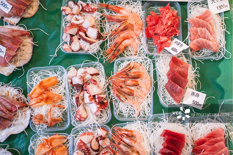 日本市场上的新鲜海鲜，有章鱼、虾和生鱼片图片素材