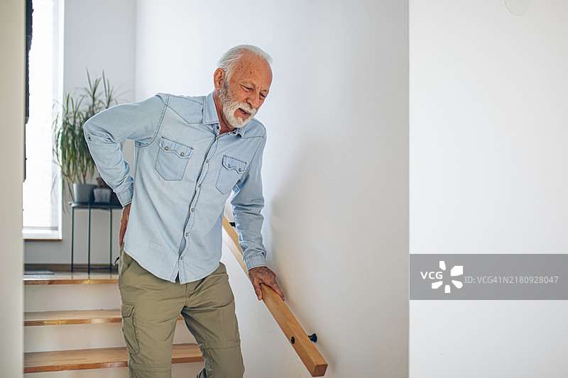 艰难地走下楼梯的年长男人图片素材