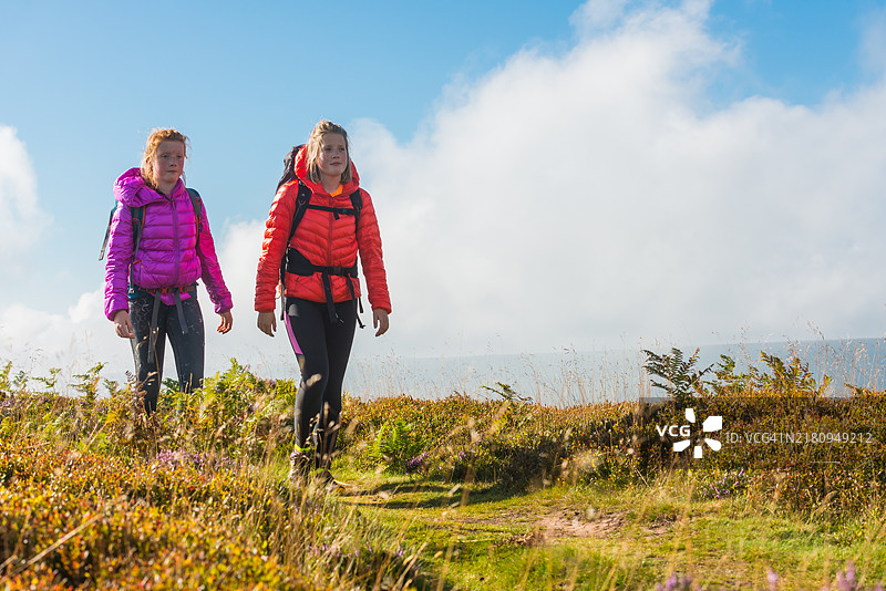 沿着夏季山脊行走的少女徒步旅行者图片素材
