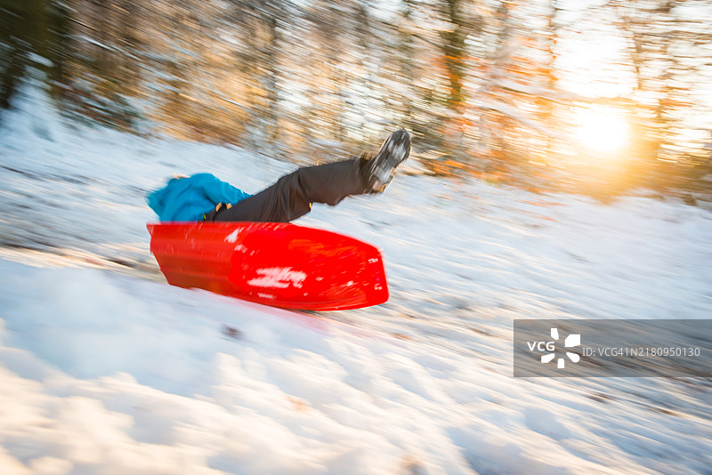 儿童在日落时分穿过白雪皑皑的森林滑雪图片素材