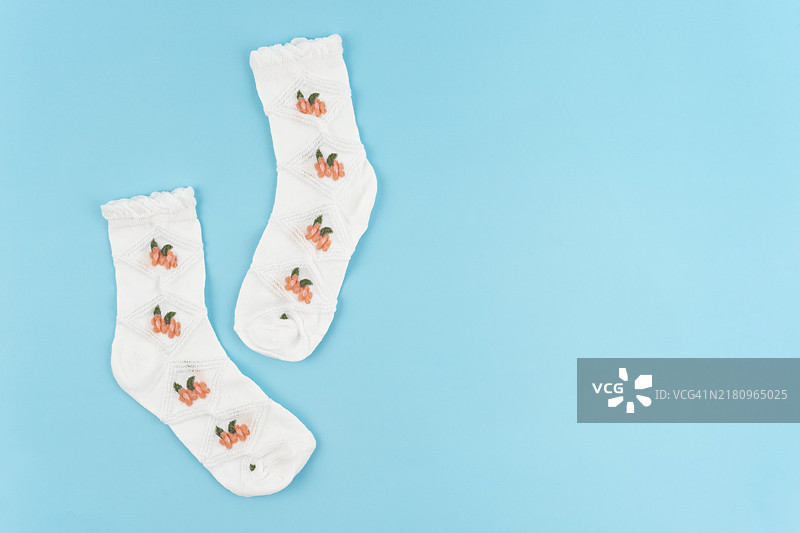 蓝色背景上的花朵图案白色保暖袜，留有文案空间图片素材