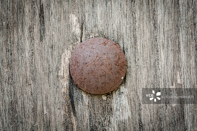 木板特写，钉着一根生锈的钉子。图片素材