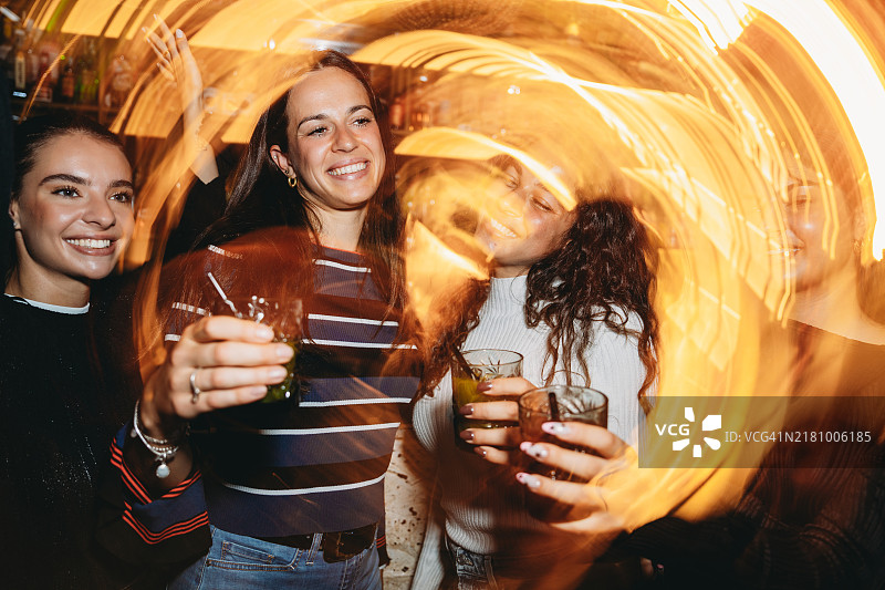 朋友们在夜总会玩乐并喝鸡尾酒图片素材