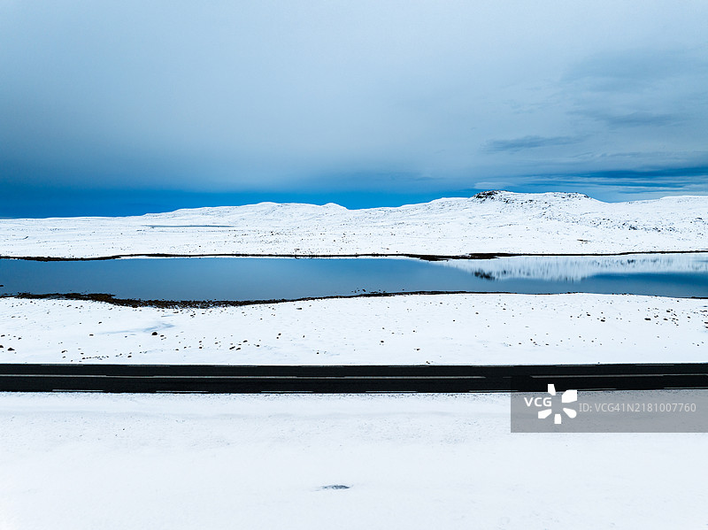 空旷的道路和白雪皑皑的雪山倒影图片素材