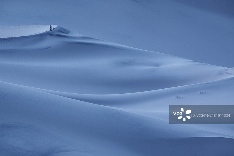 一位摄影师在加利福尼亚州死亡谷的尤里卡沙丘拍摄蓝色时光的沙丘。图片素材