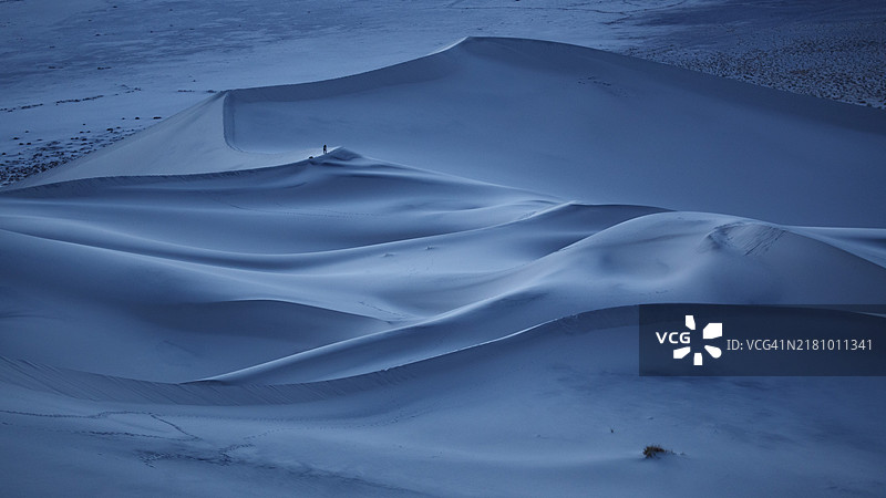 一位摄影师在加利福尼亚州死亡谷的尤里卡沙丘拍摄蓝色时光的沙丘。图片素材