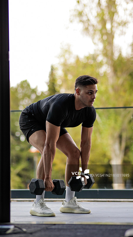 青年男子做哑铃硬拉，下半身和核心肌肉的力量训练视频图片素材