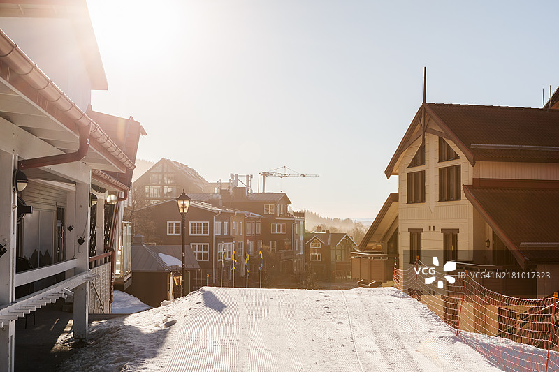 一条滑雪道一直延伸到山村。图片素材