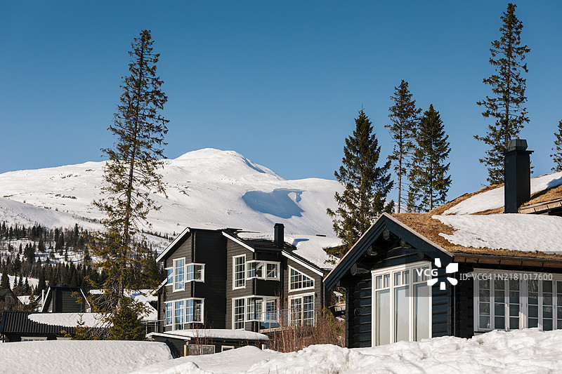 一座大型滑雪山，前景有山间小屋。图片素材