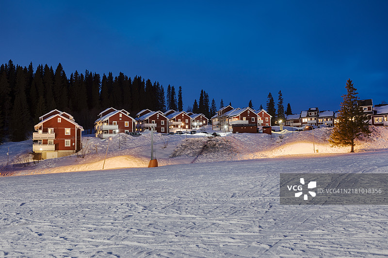 黄昏时分，阿尔卑斯滑雪度假村中的小屋村庄。图片素材