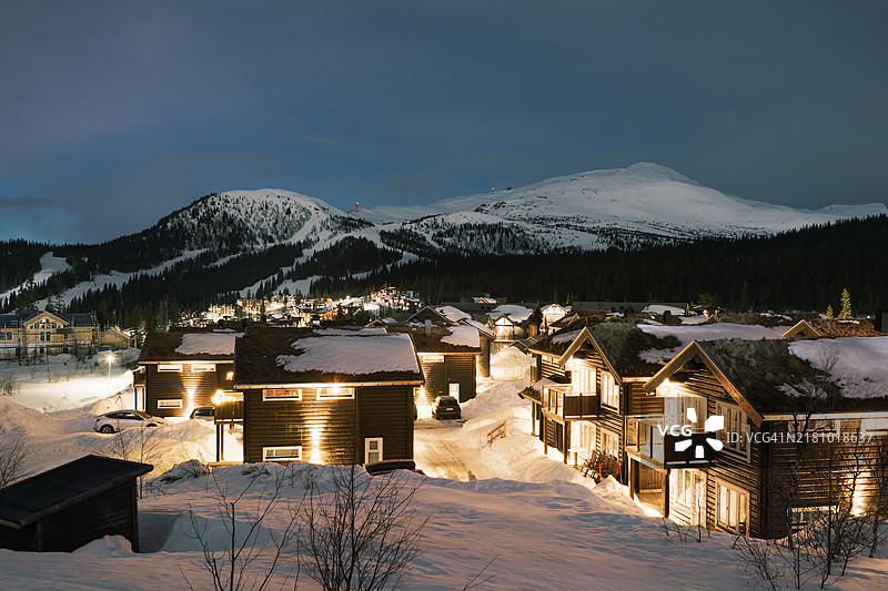 黄昏时分的滑雪山，前景是小木屋村庄。图片素材