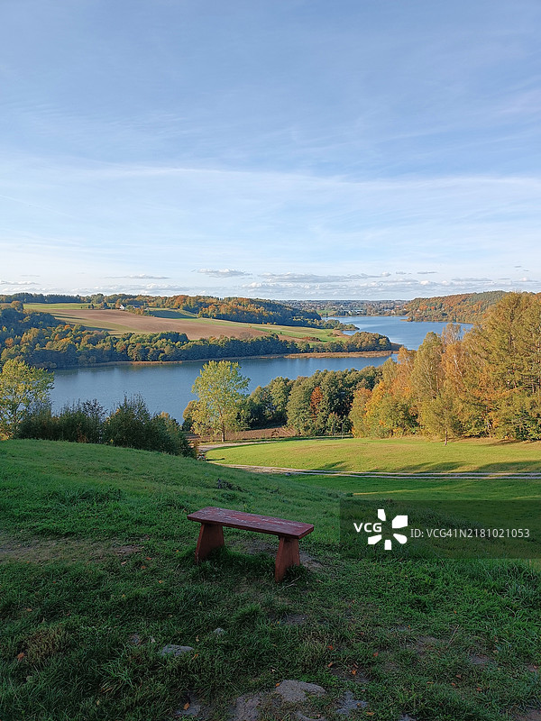 孤独的长椅，秋季森林山丘河流的如画景色，黄色和绿色的树叶，十月，放松，宁静。图片素材