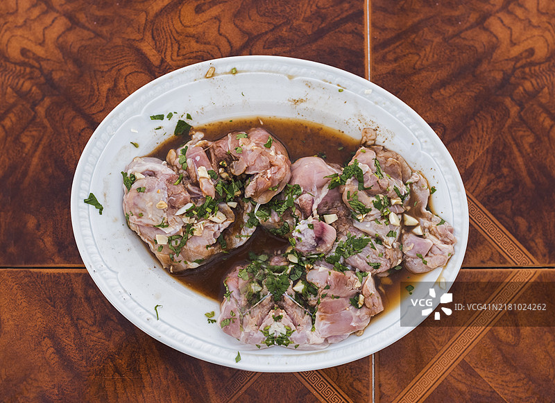 一盘用大蒜、香菜油和香料调味的鸡腿肉的美食视图图片素材