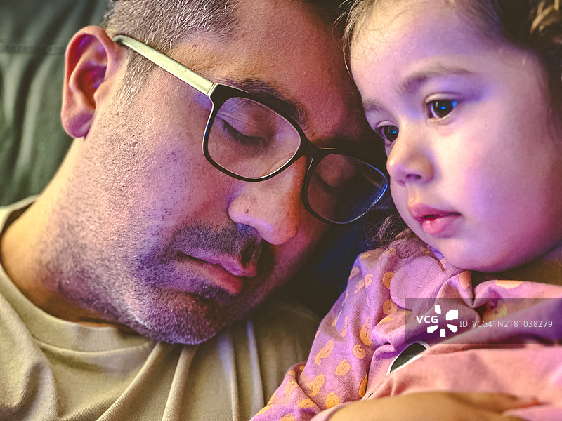 父亲在睡觉，女儿在看电视图片素材