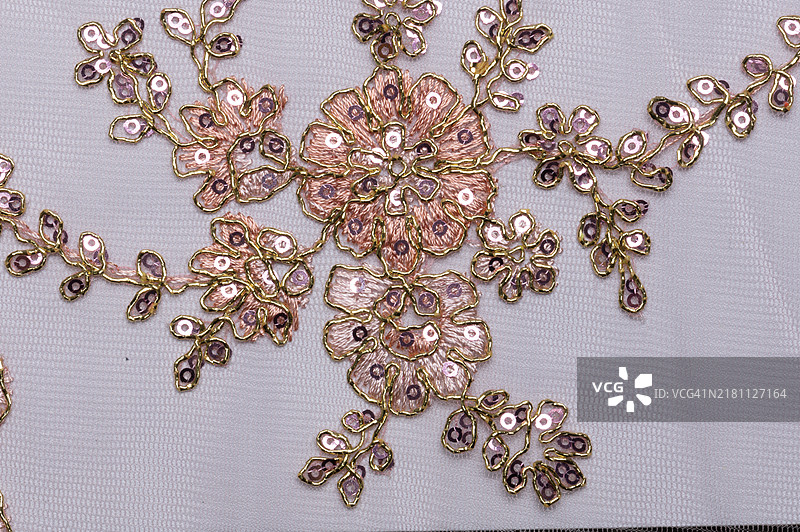 白色织物上粉色和金色刺绣特写图片素材