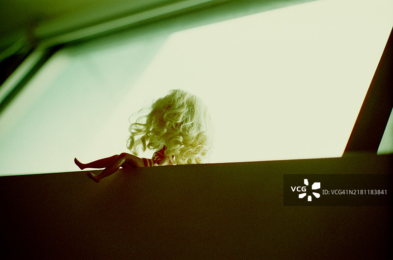 窗边坐着的洋娃娃图片素材