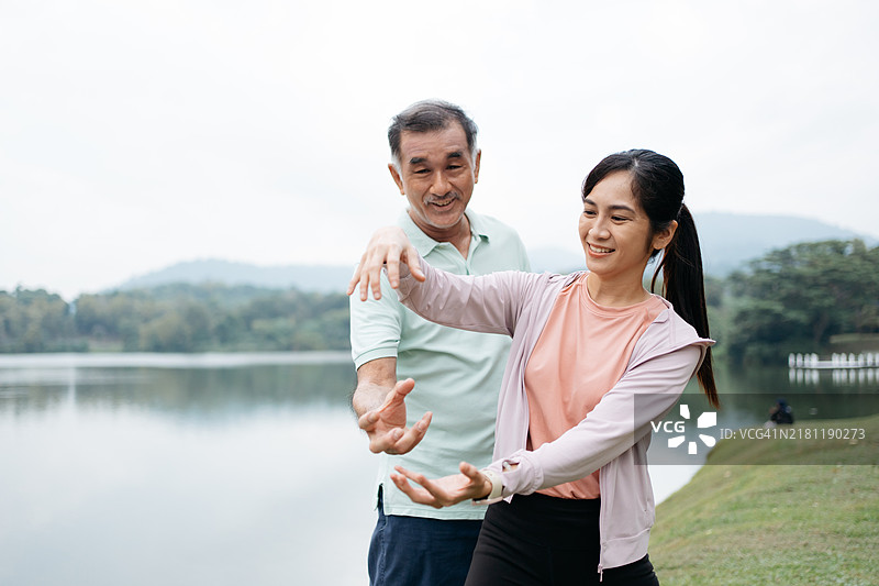 亚洲家庭在公园里进行太极训练图片素材