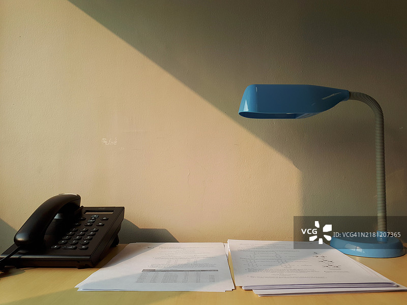 带灯和电话的家庭办公室桌子图片素材