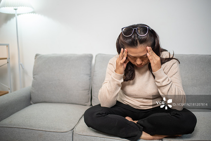 亚洲女到压力、疲惫，头痛、眩晕，偏头痛，身体不适，捂着头，反映人们的健康问题图片素材