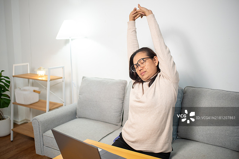 亚洲女性因整天辛勤工作而感到手臂肌肉疼痛。图片素材