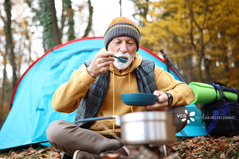 经验丰富的徒步旅行者在休息时准备营火餐。图片素材
