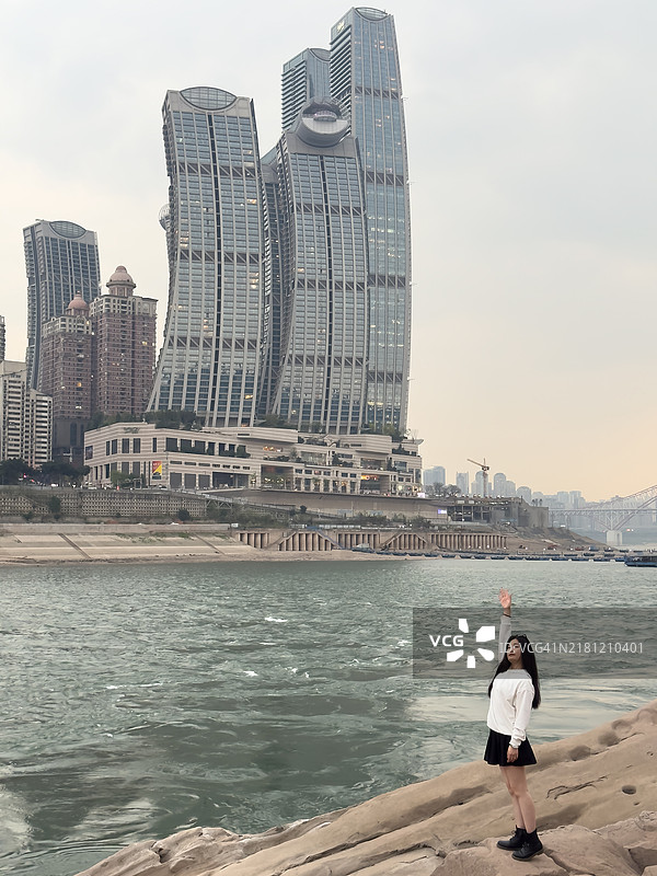 现代城市中拥有城市天际线和摩天大楼的年轻女性图片素材