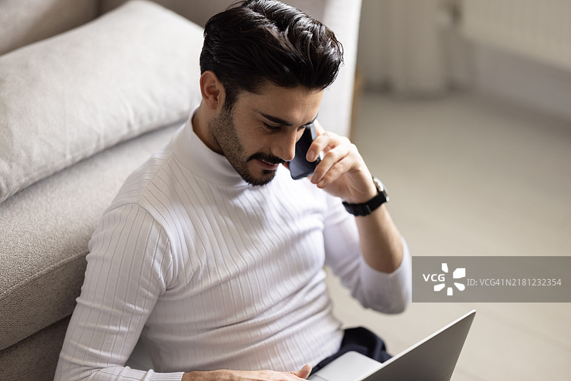 英俊的白人男子在家看笔记本电脑在线工作肖像图片素材