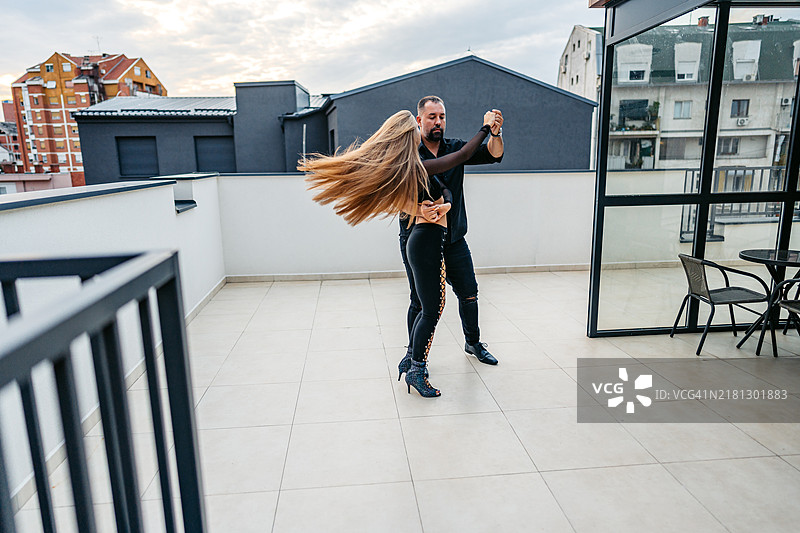中年男人和年轻女子在楼顶跳拉丁舞图片素材