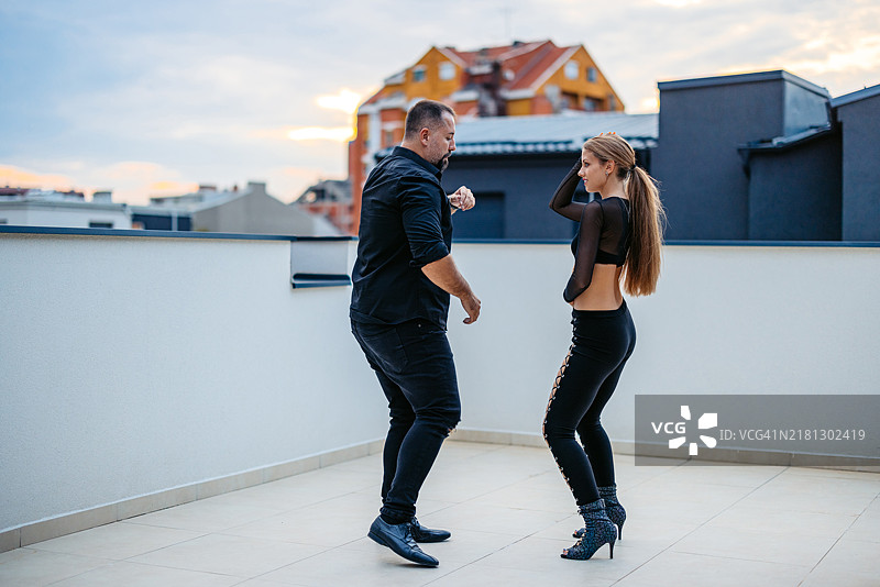 中年男人和年轻女子在楼顶跳拉丁舞图片素材
